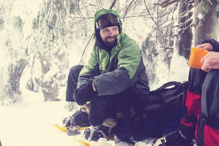 Couple of guys around winter campfire