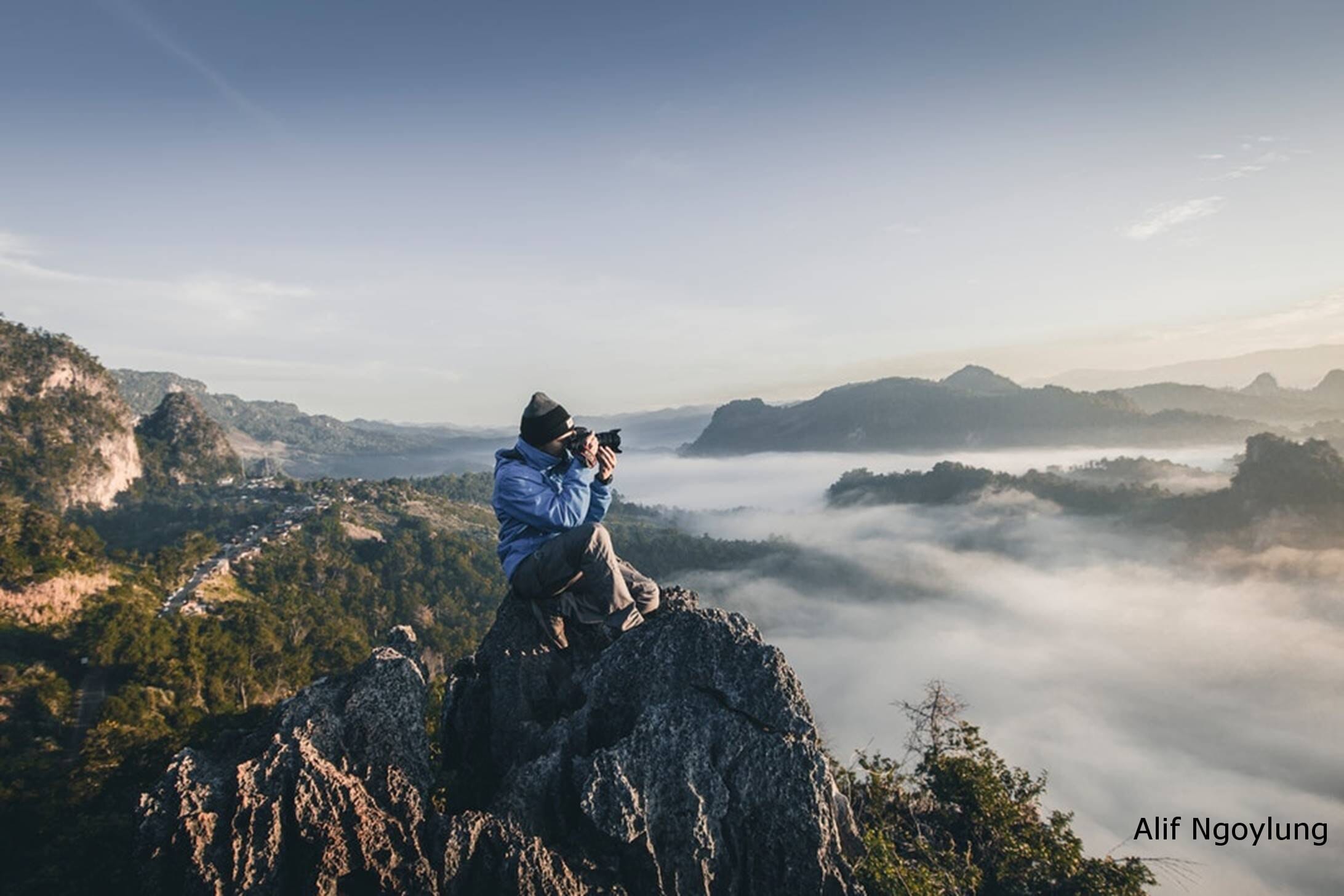 Photographer atop peak overlooking falls